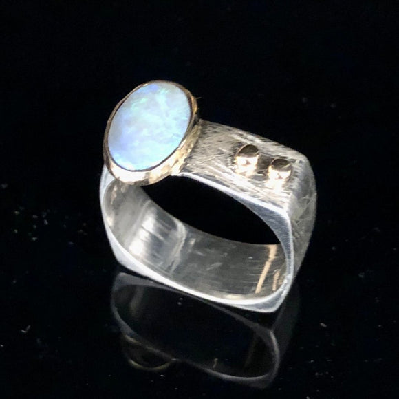 Silver ring with a blue gemstone on a black background