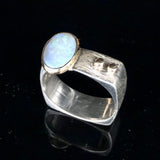Silver ring with a blue gemstone on a black background