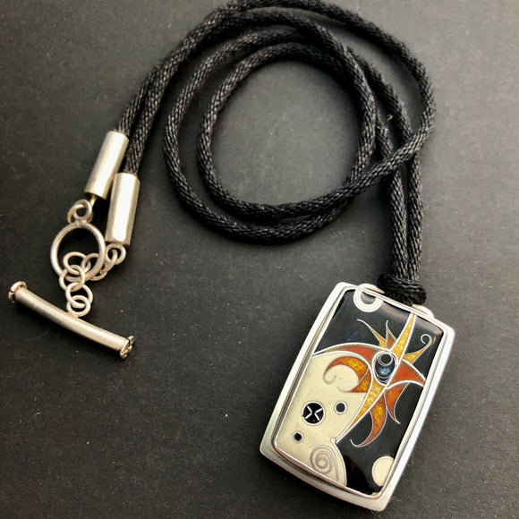 Necklace with a decorative pendant on a dark surface